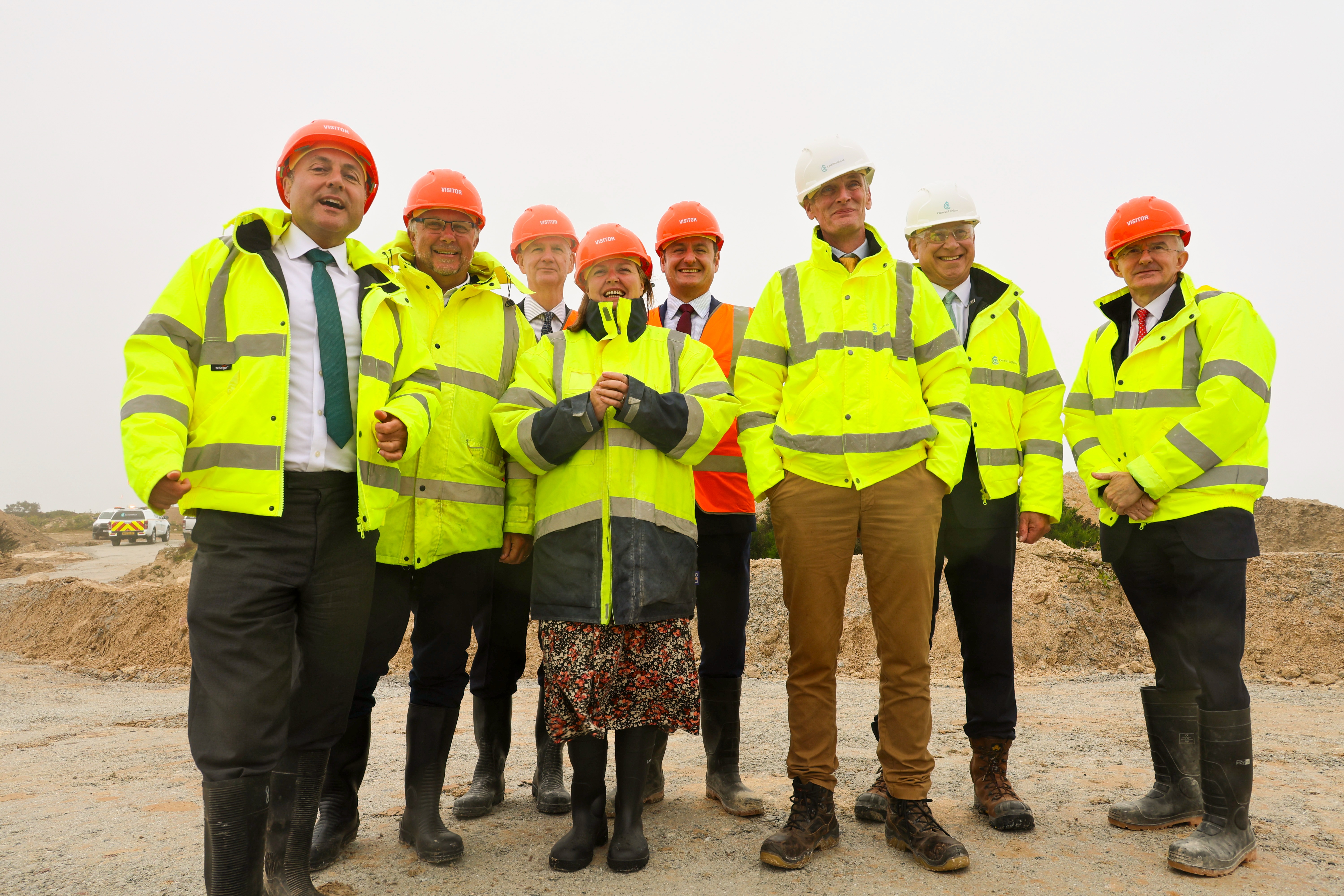 People in high visibility jackets and hard hats standing in a quarry
